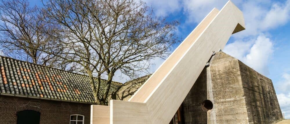 Houten Bunkertreppe tegen een bunker aan met een boom ernaast