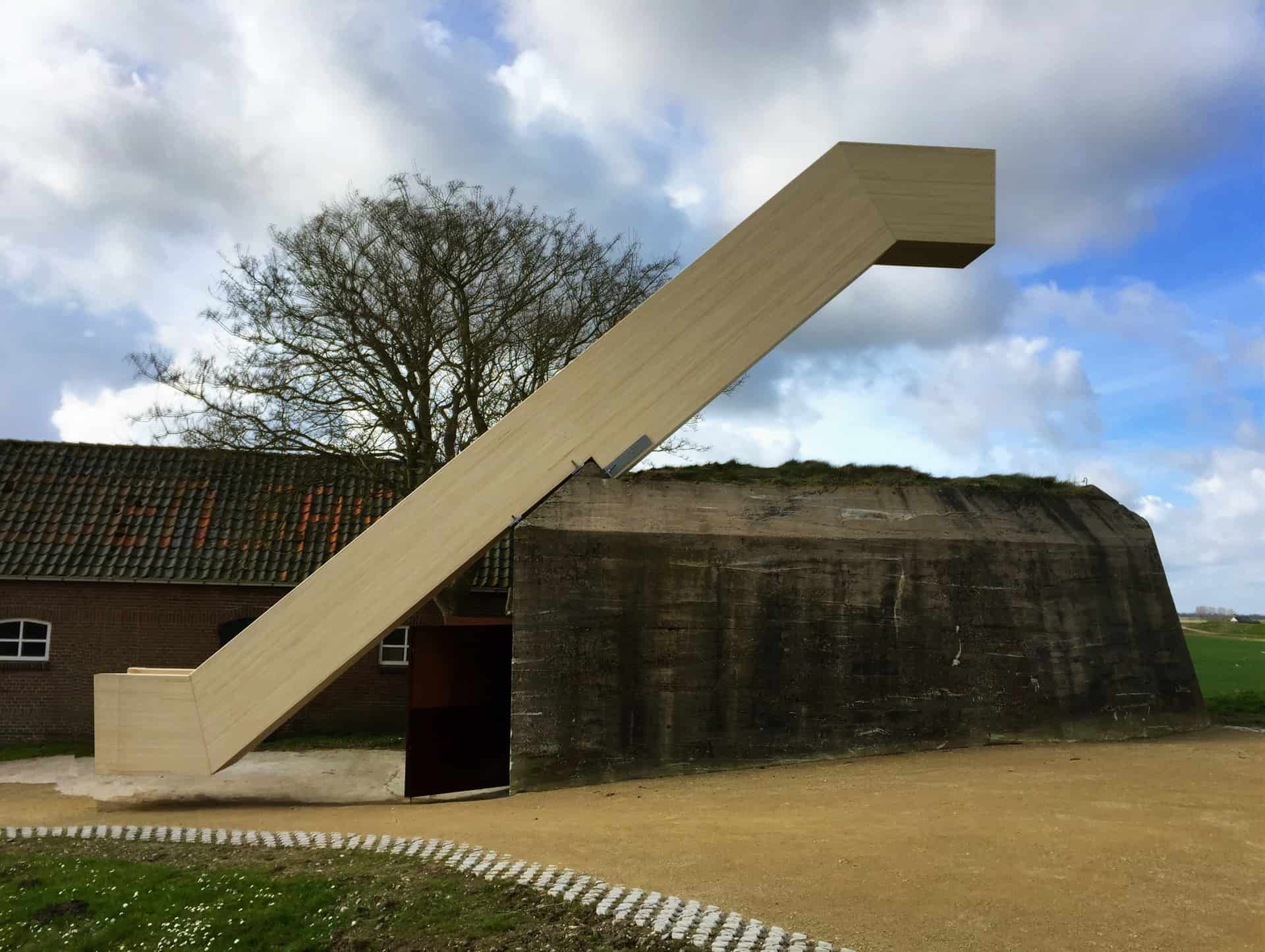 Houten trap voor een bunker met zand en gras eronder