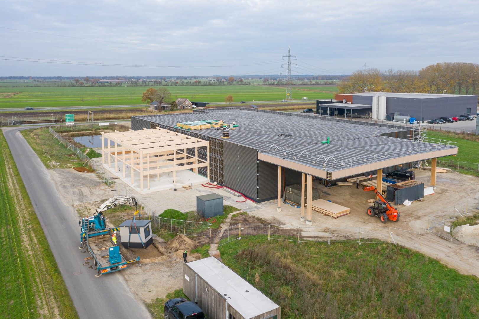 Een houten hal in aanbouw een groen landschap van bovenaf