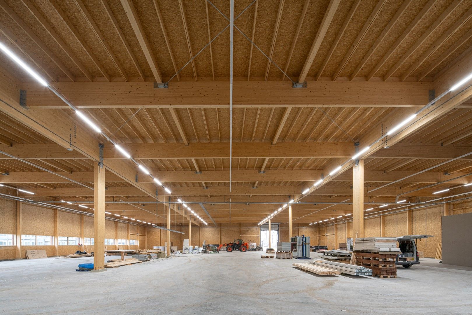 Houten hal met grijze vloer in aanbouw met materiaal