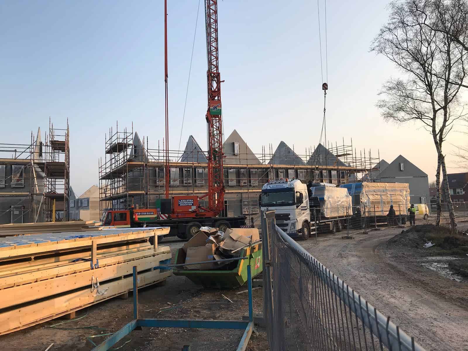 Zon die door huizen schijnt op bouwplaats