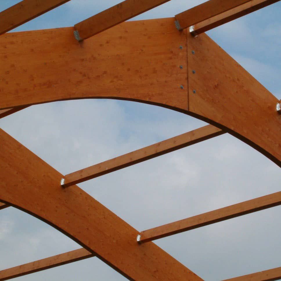 Houten dakconstructie van dichtbij met blauwe lucht