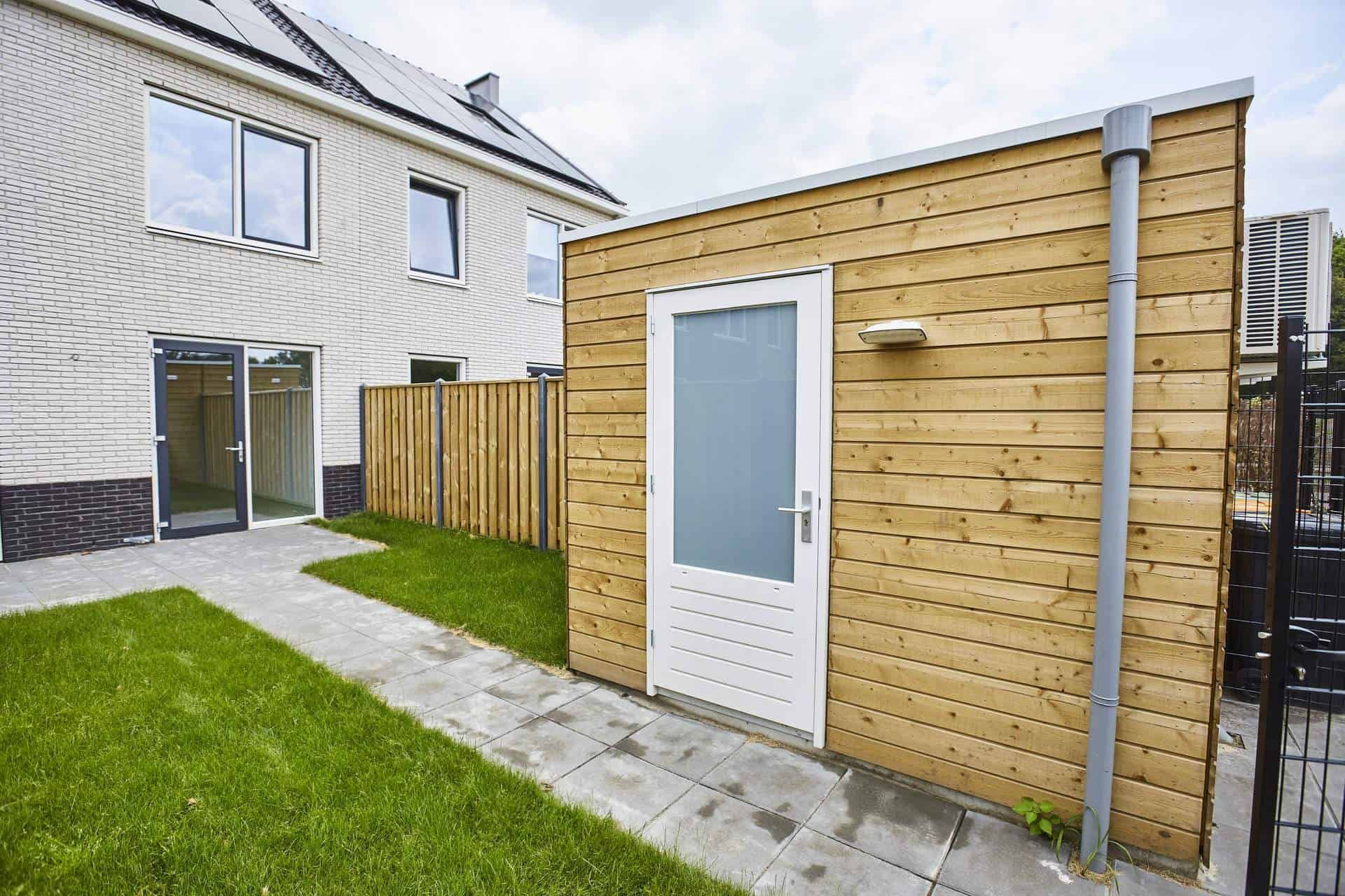 Gele houten berging in achtertuin