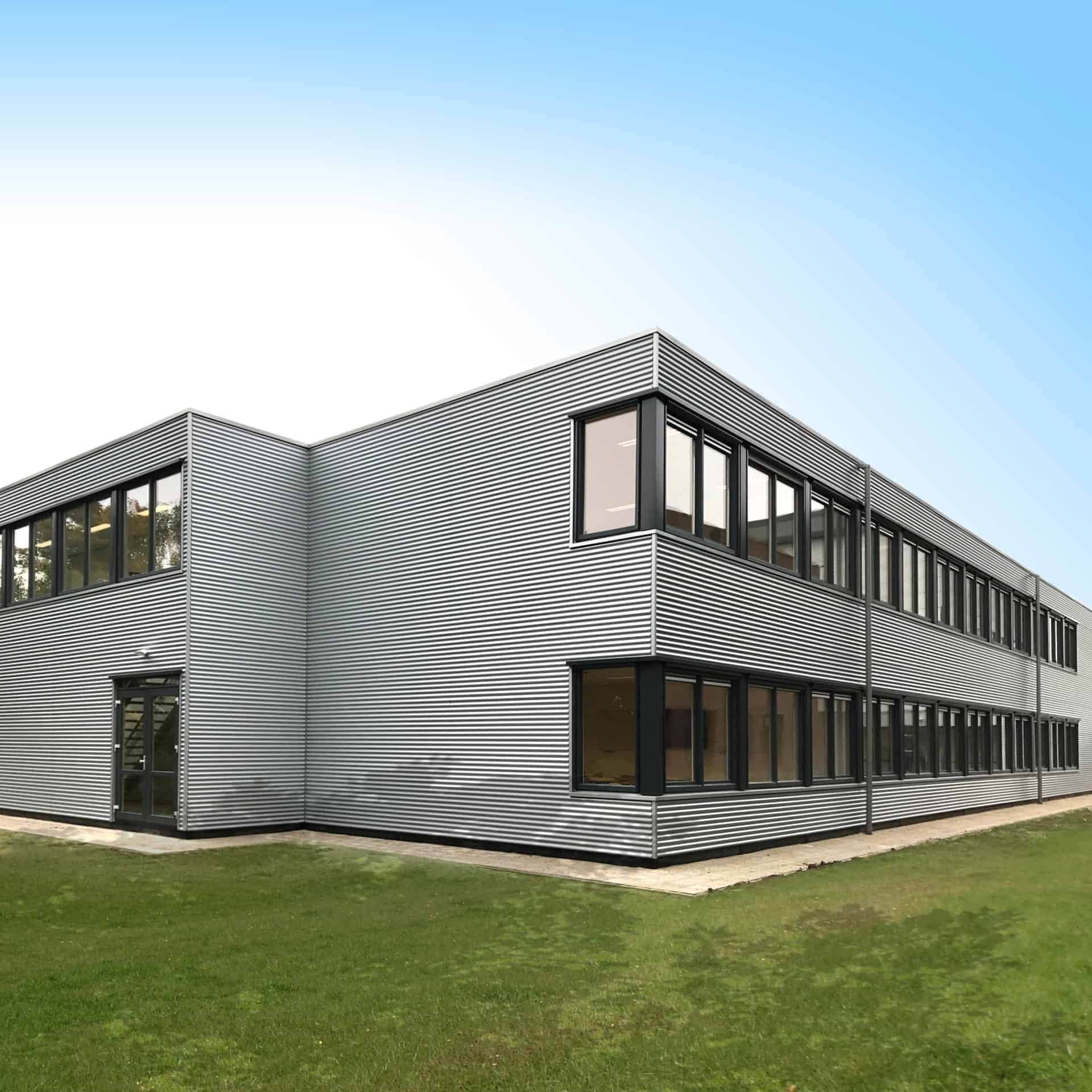 De hoek van de grijze Helen Parkhurst school met een omliggend grasveld