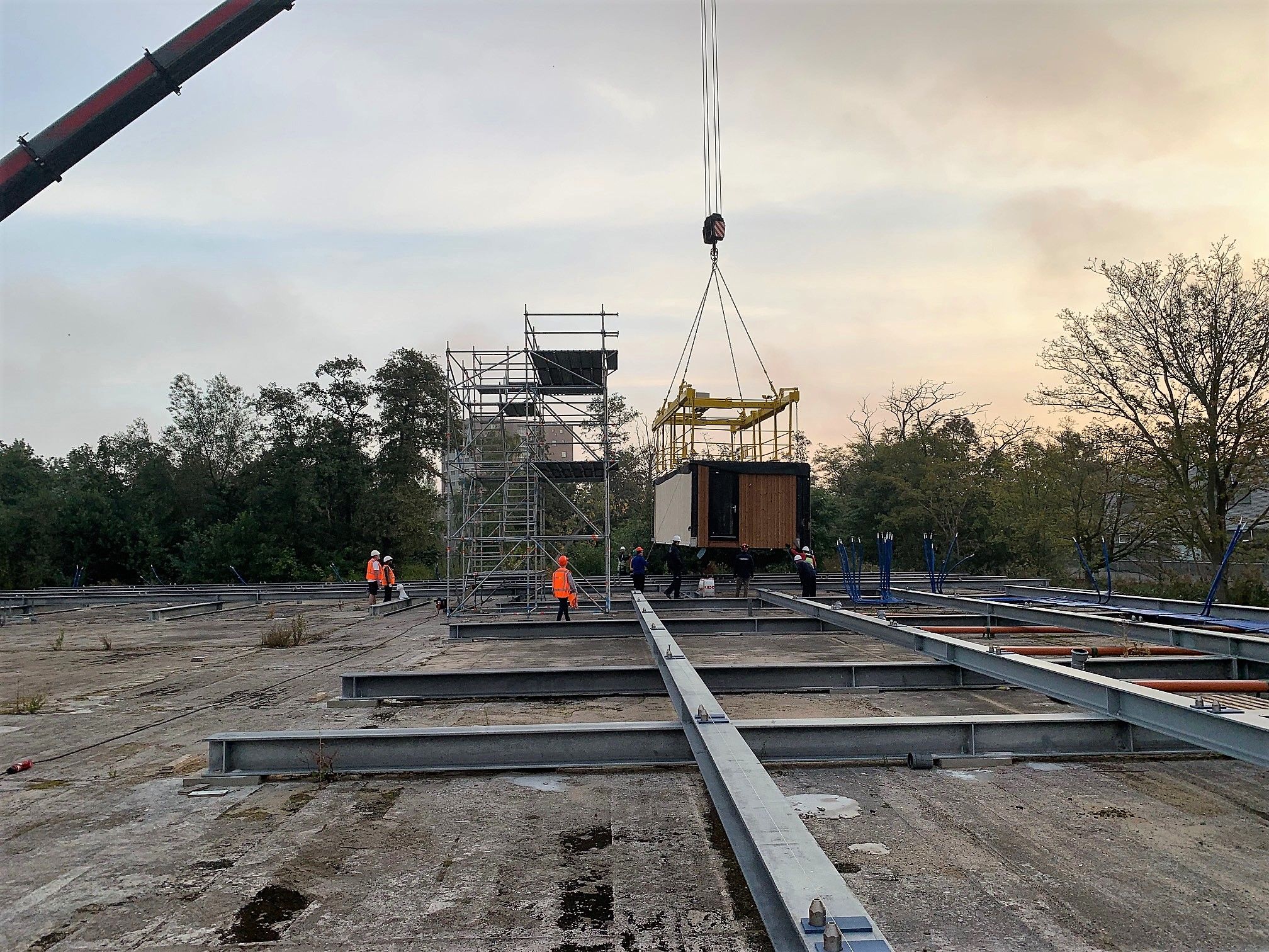 Houten module aan hijskraan met een bouwsteiger