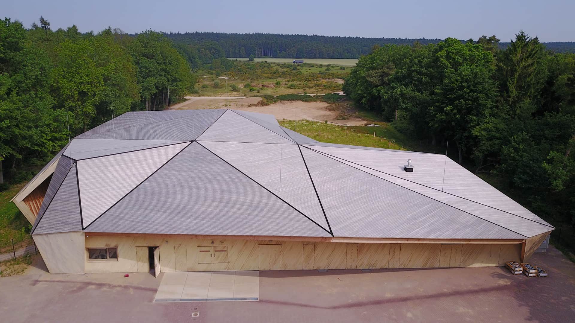 Houten gebouw met schuine daken op een oppervlakte aan groen
