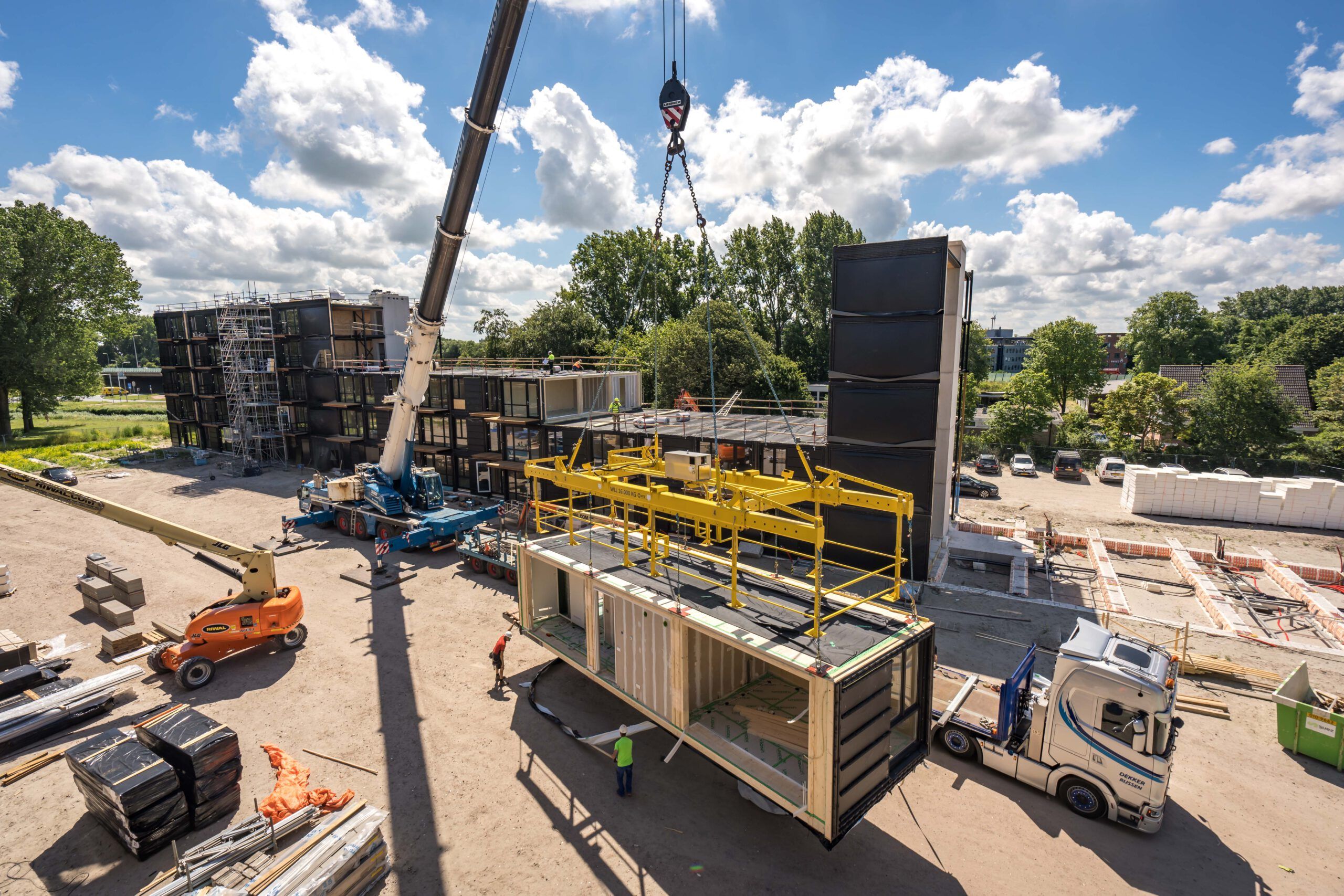 Prefab houtbouw element die met kraan op gebouw wordt getild