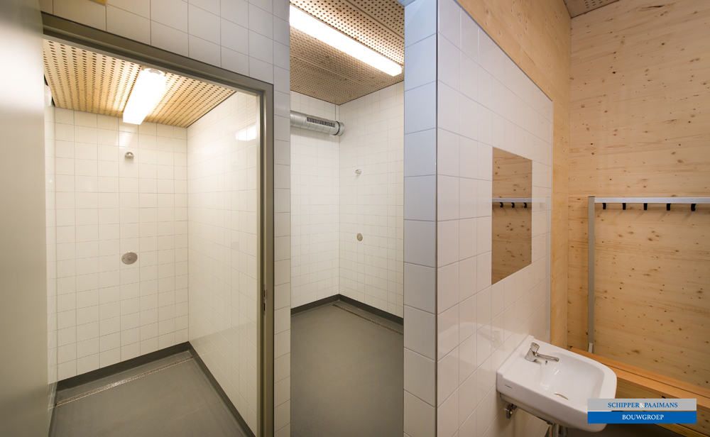De sanitaire voorzieningen met houten plafond en witte tegels