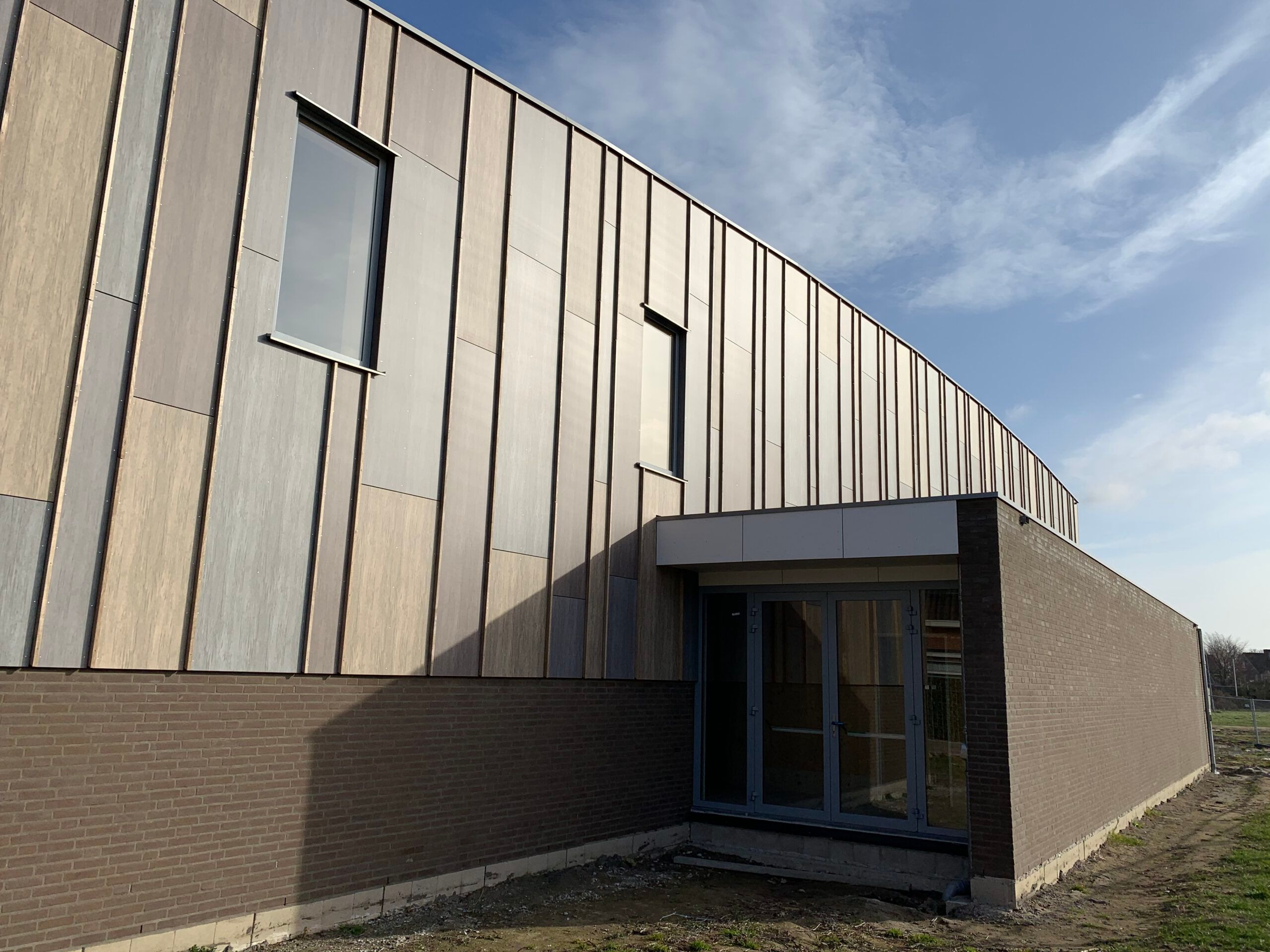 Ingang houten gebouw met onderaan baksteden