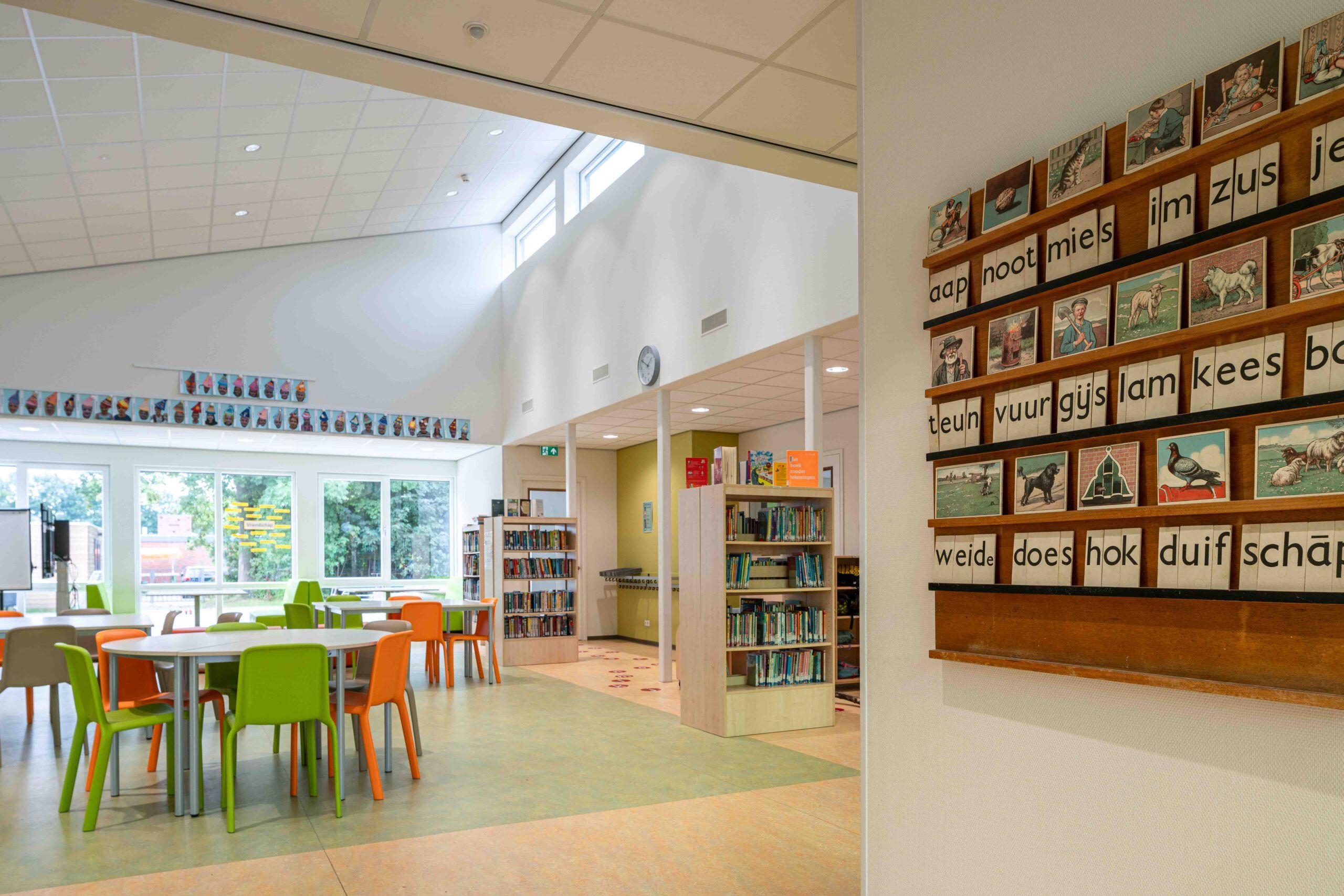 Een lokaal met oranje en groene stoelen en boeken van basisschool In 't Zandt