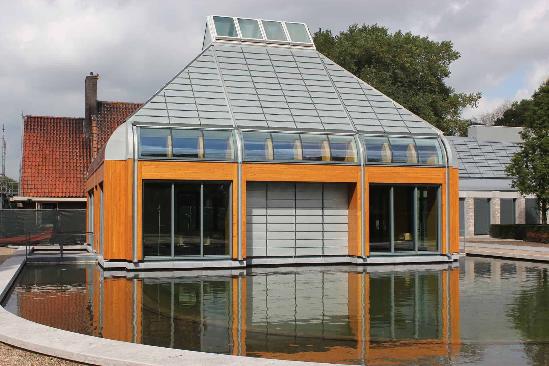 Gebouwte met glas omringd door een kleine vijver