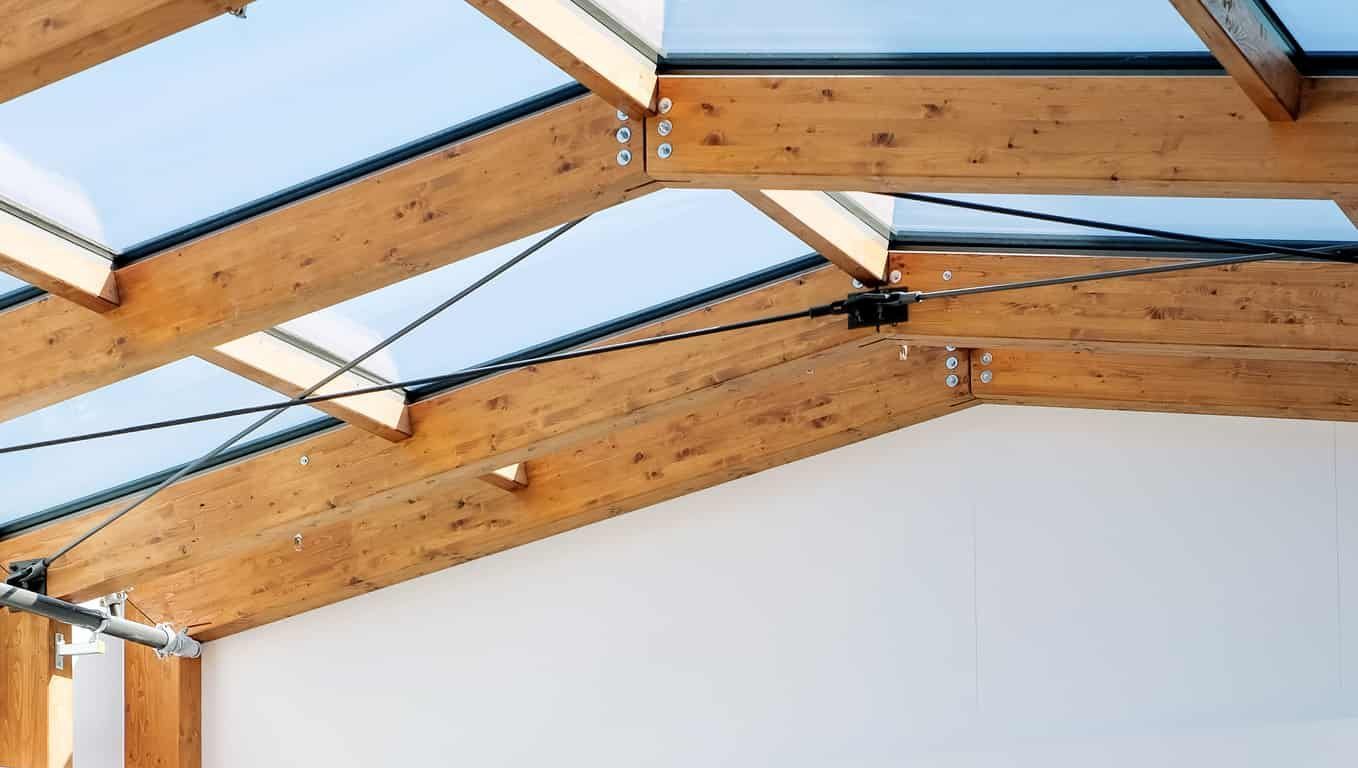 Houten balken op het dak met glas ertussen