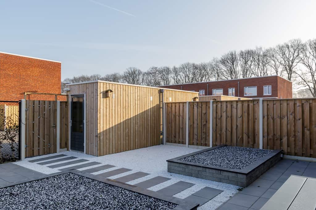 Schuttingen in een moderne tuin met grijze tegels en stenen
