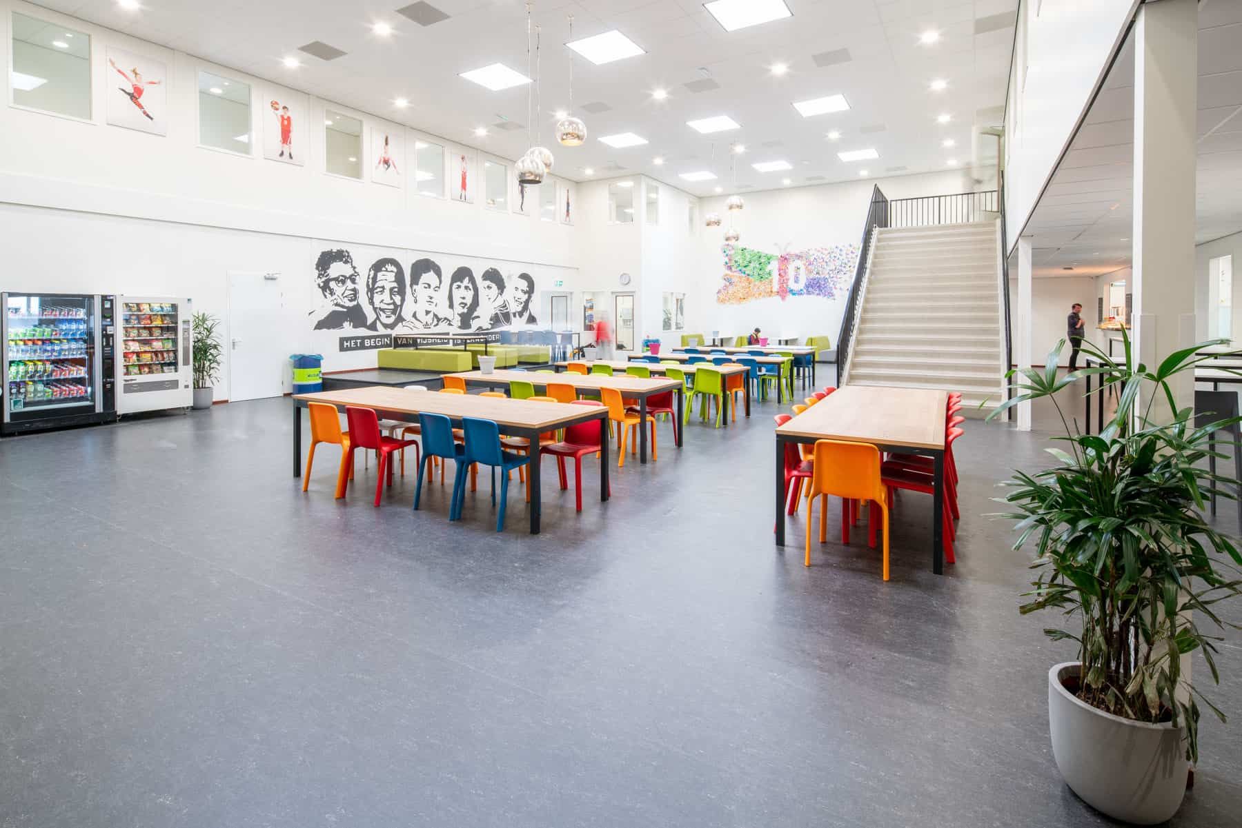 Het overzicht van de hele kantine met kleurrijke stoelen van de Nuovo scholengroep in Utrecht