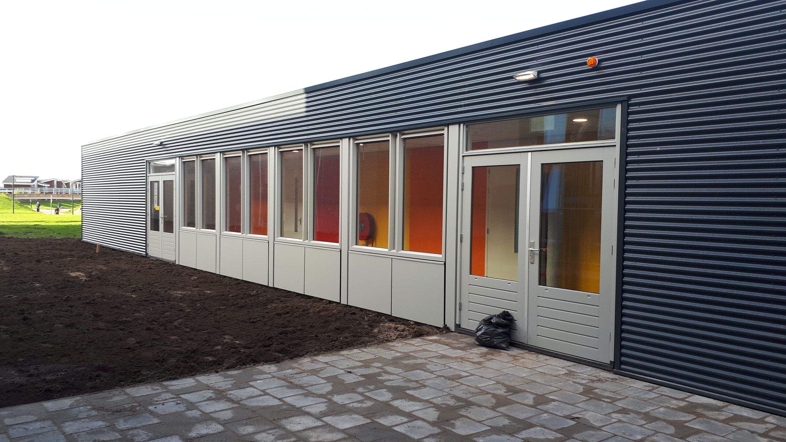 De ingang met witte kozijnen en kleurrijke binnenkant van de tijdelijke school in Dronten