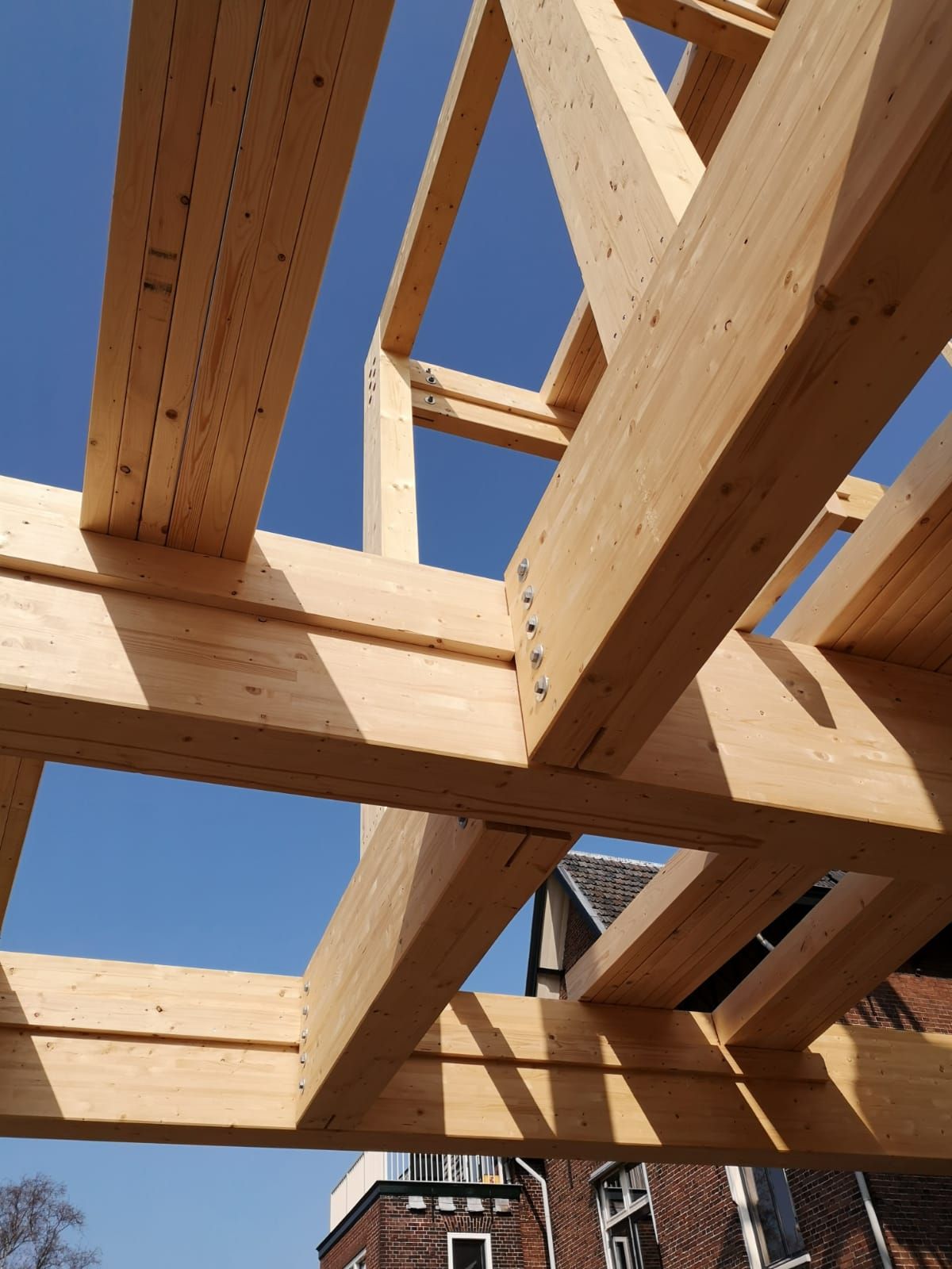 Houten constructie met balken met huizen erachter