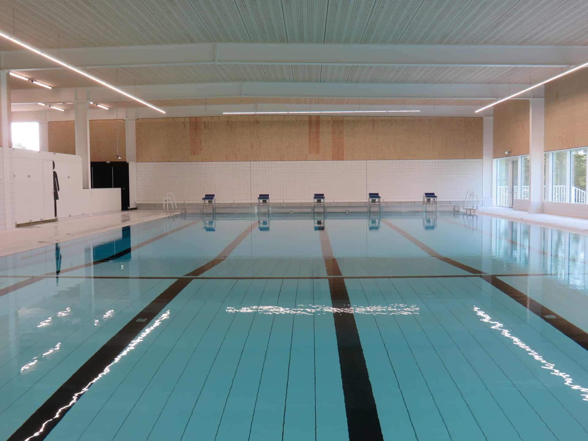 Binnen zwembad gevuld met water en hout met tegels als muur