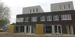 Zwart met wit huis met veel ramen en gele dixie