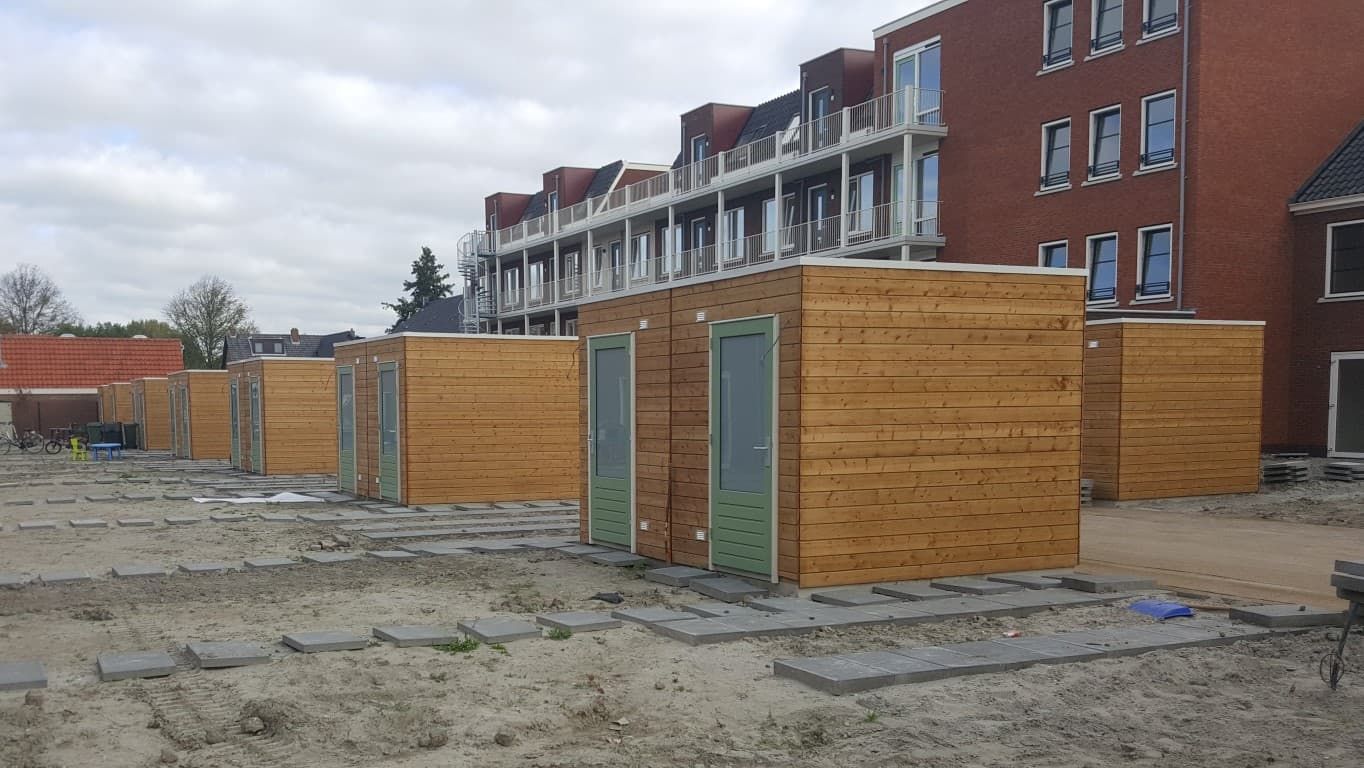 Houten schuurtjes met groene deuren