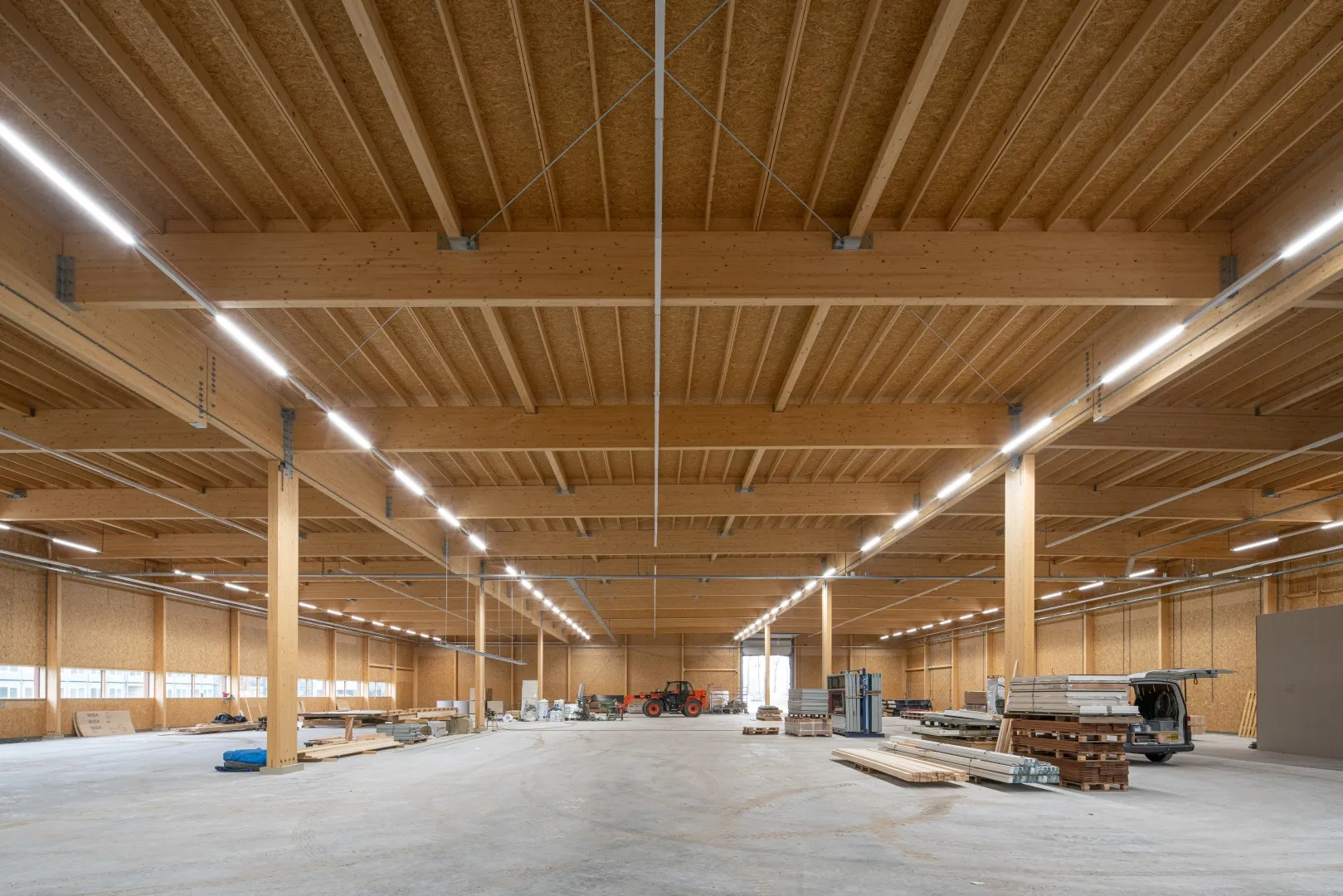 Houten hal met grijze vloer in aanbouw met materiaal