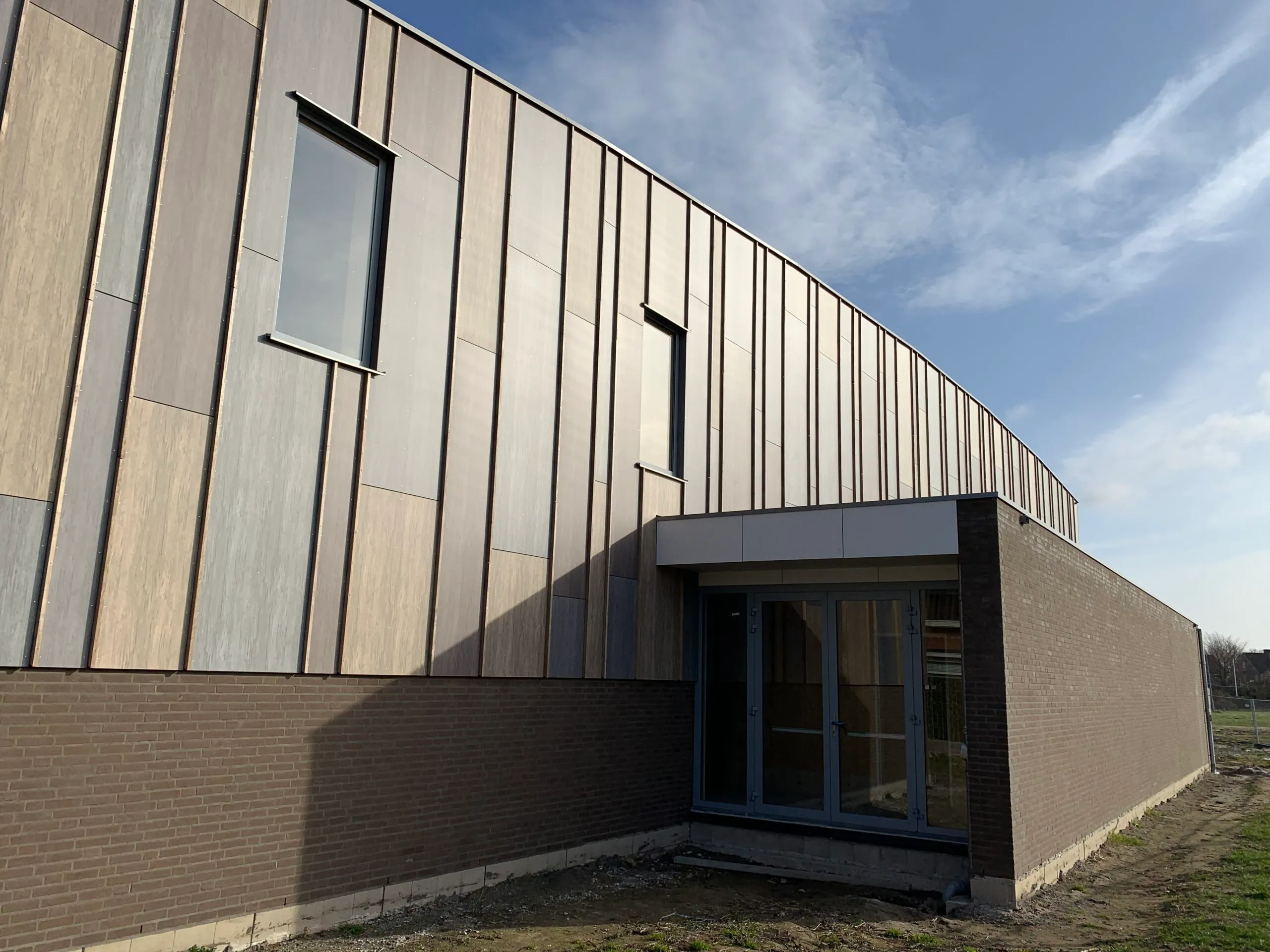 Ingang houten gebouw met onderaan baksteden
