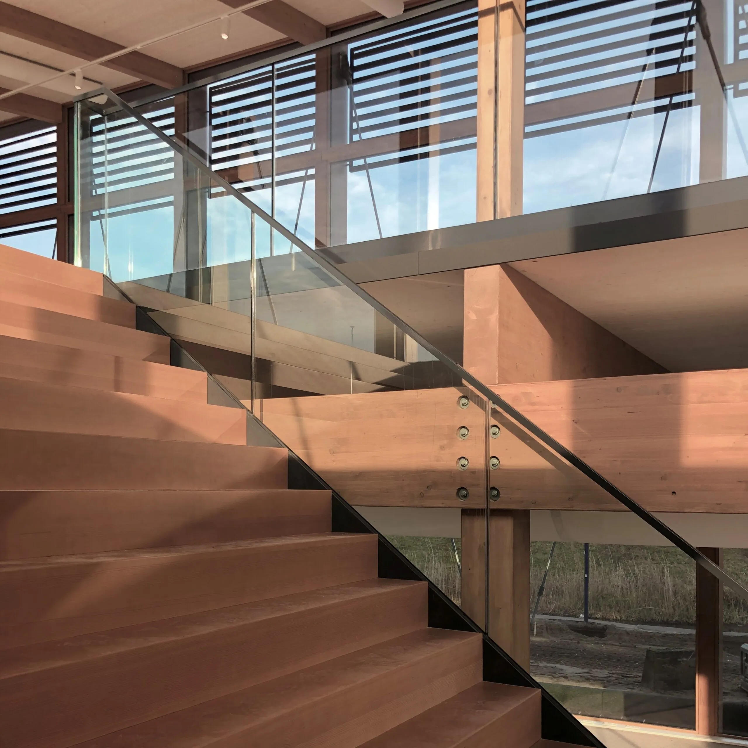 Houten trap met glazen trapleuning