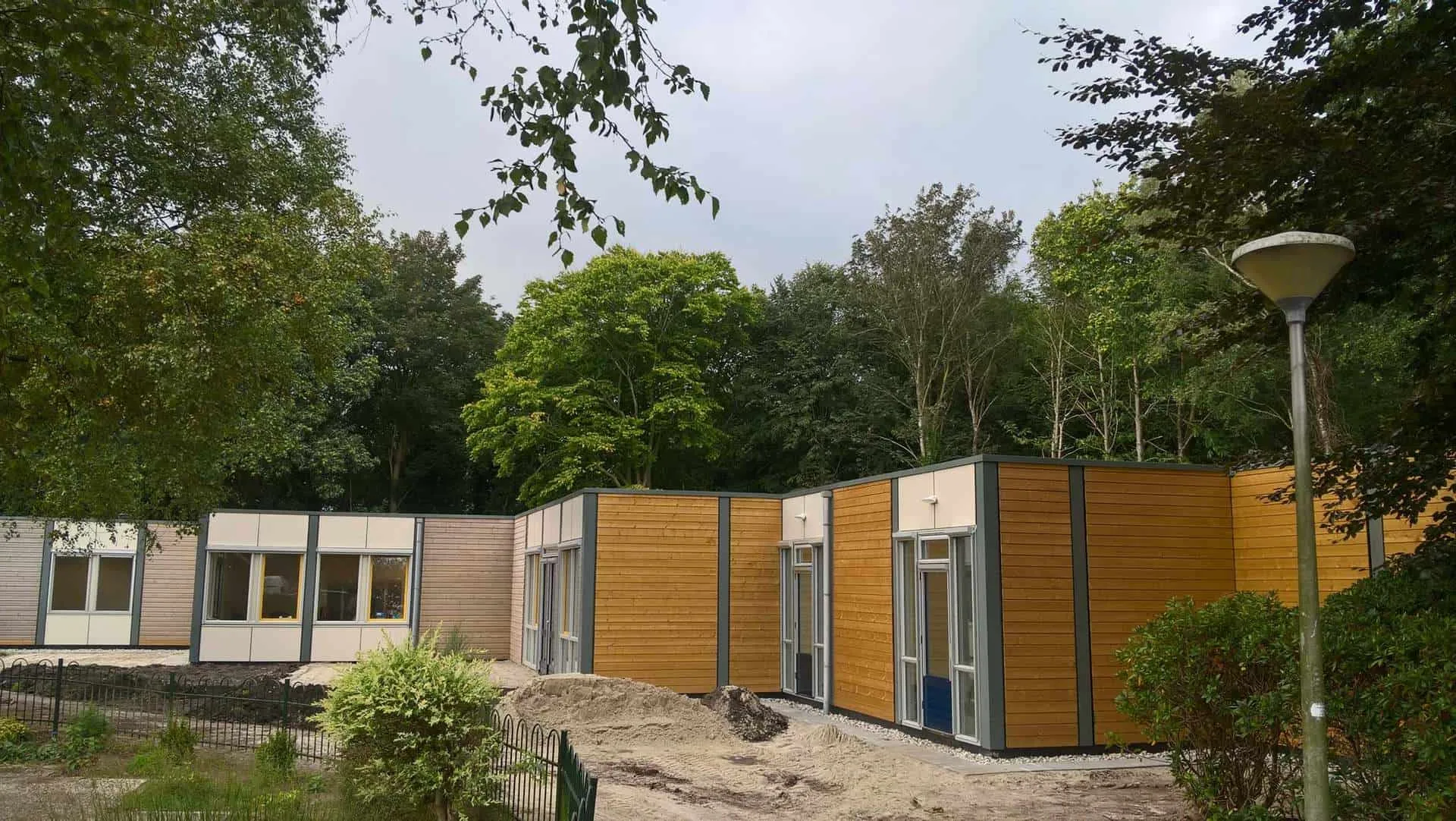 Houten woningen langs pad met bomen