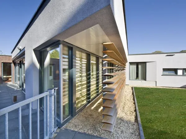 De hoek van het witte bungalowcomplex De Beemden met houten luxaflex, grind en gras