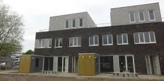 Zwart met wit huis met veel ramen en gele dixie