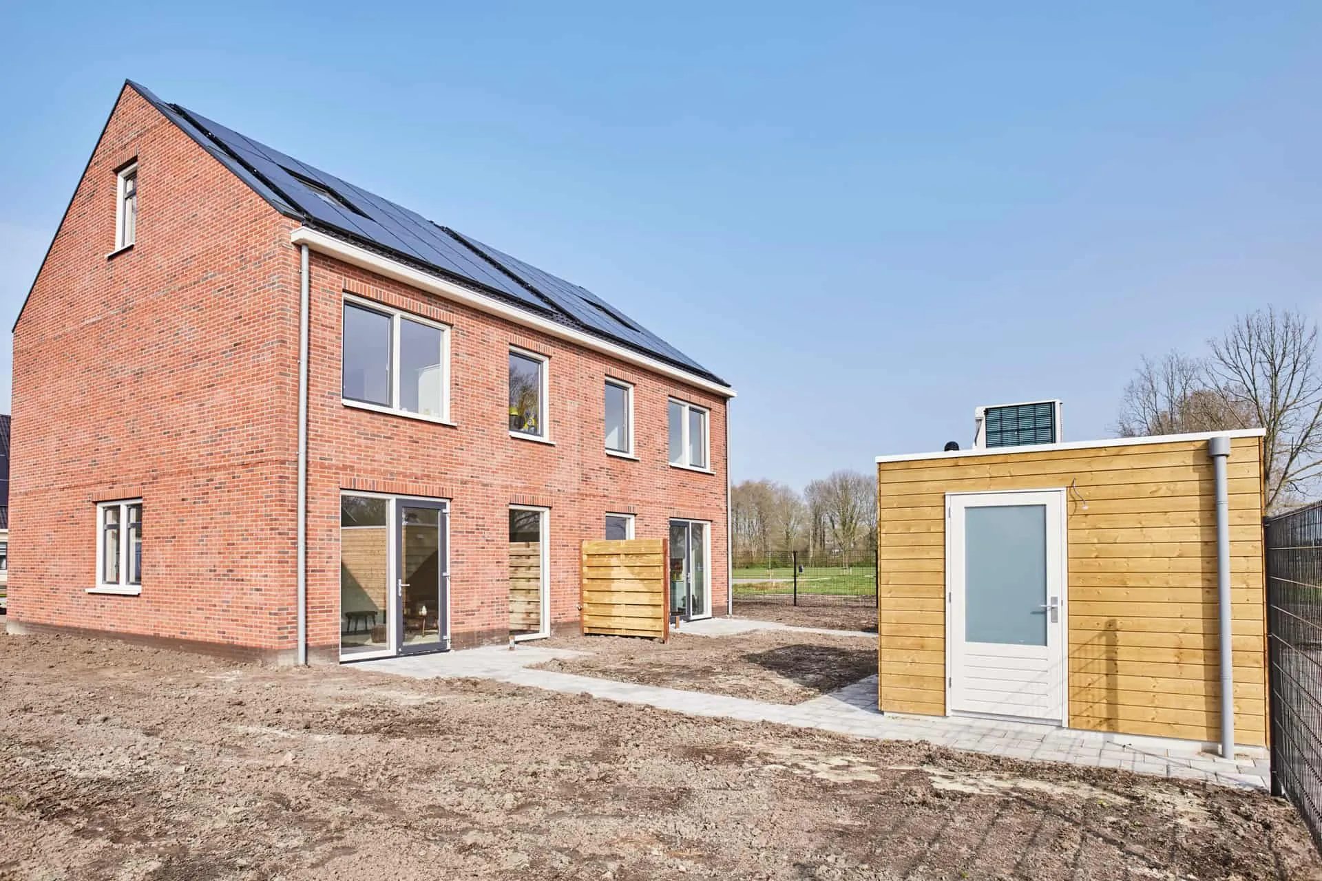 Houten berging in een lege tuin in aanbouw