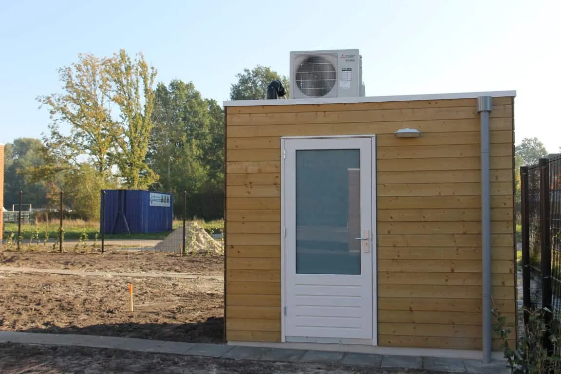 Houten berging met airco op het dak