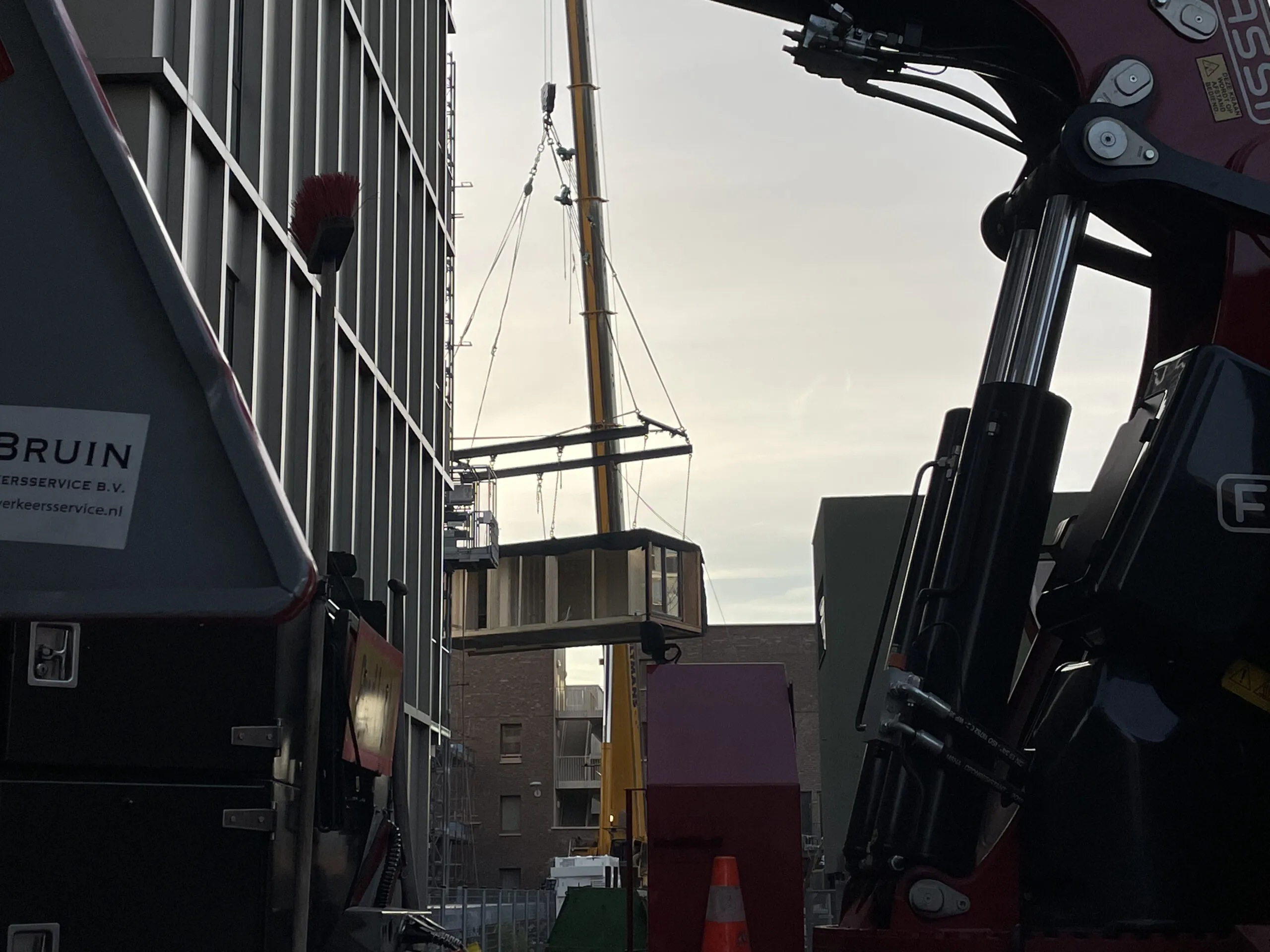 Verplaatsing houten woonmodule aan een kraan