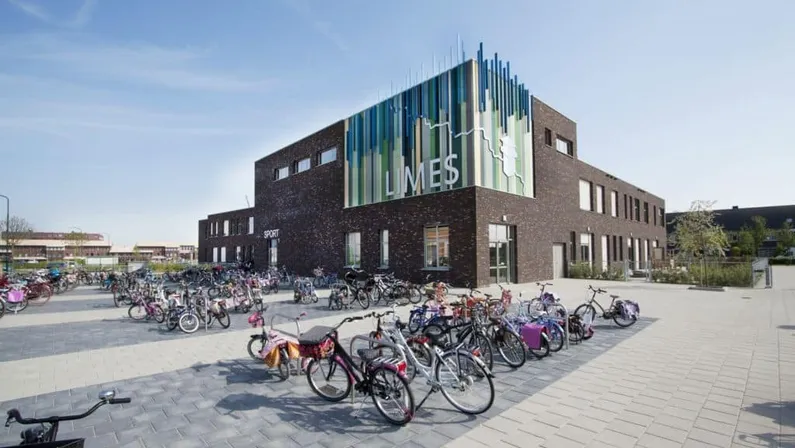 Bredeschool MFA Limes met kleurrijke voorgevel en fietsen vooraan