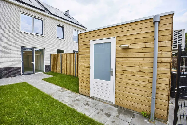 Gele houten berging in achtertuin