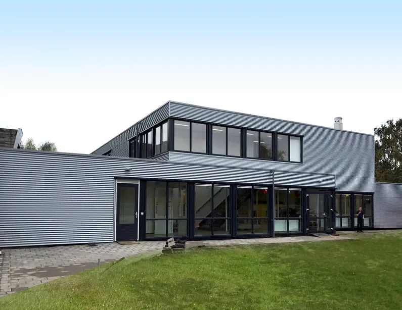 De grijze Helen Parkhurst school van buiten met zwarte kozijnen