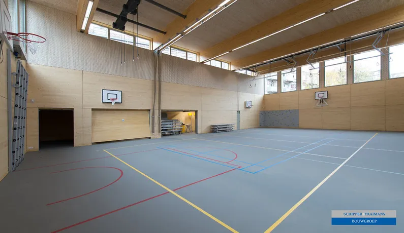 Houten sporthal met blauwe vloer met lijnen, baskets, ringen, een klimrek en opberghokken