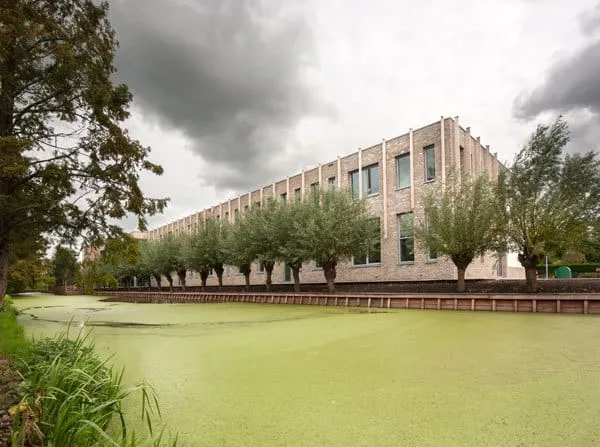 Wellantscollege in Boskoop vanaf veraf met veel groen en bomen