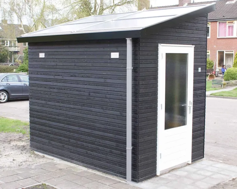 Zwarte kleine berging met zonnepanelendak