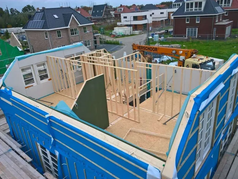 Woning in aanbouw zonder dak van boven met houten wand-elementen